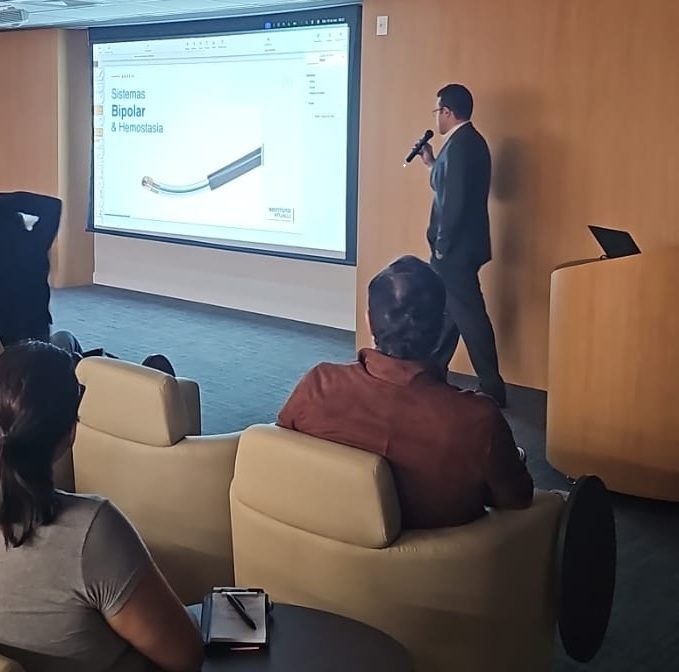 Palestrante apresentando um dispositivo para a plateia